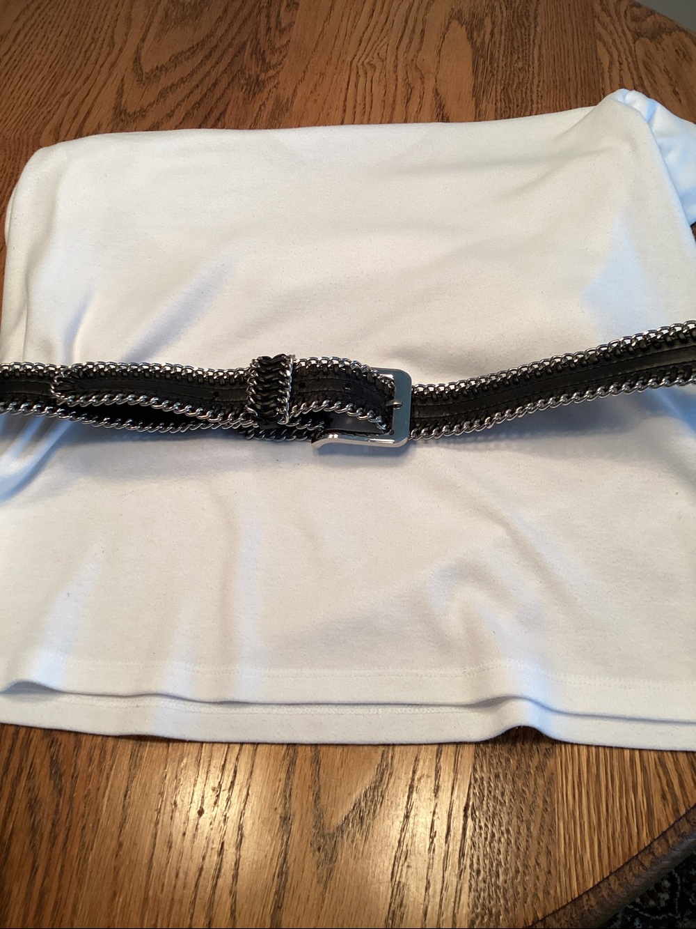 Faux black leather belt with parallel metallic curb chain link border.